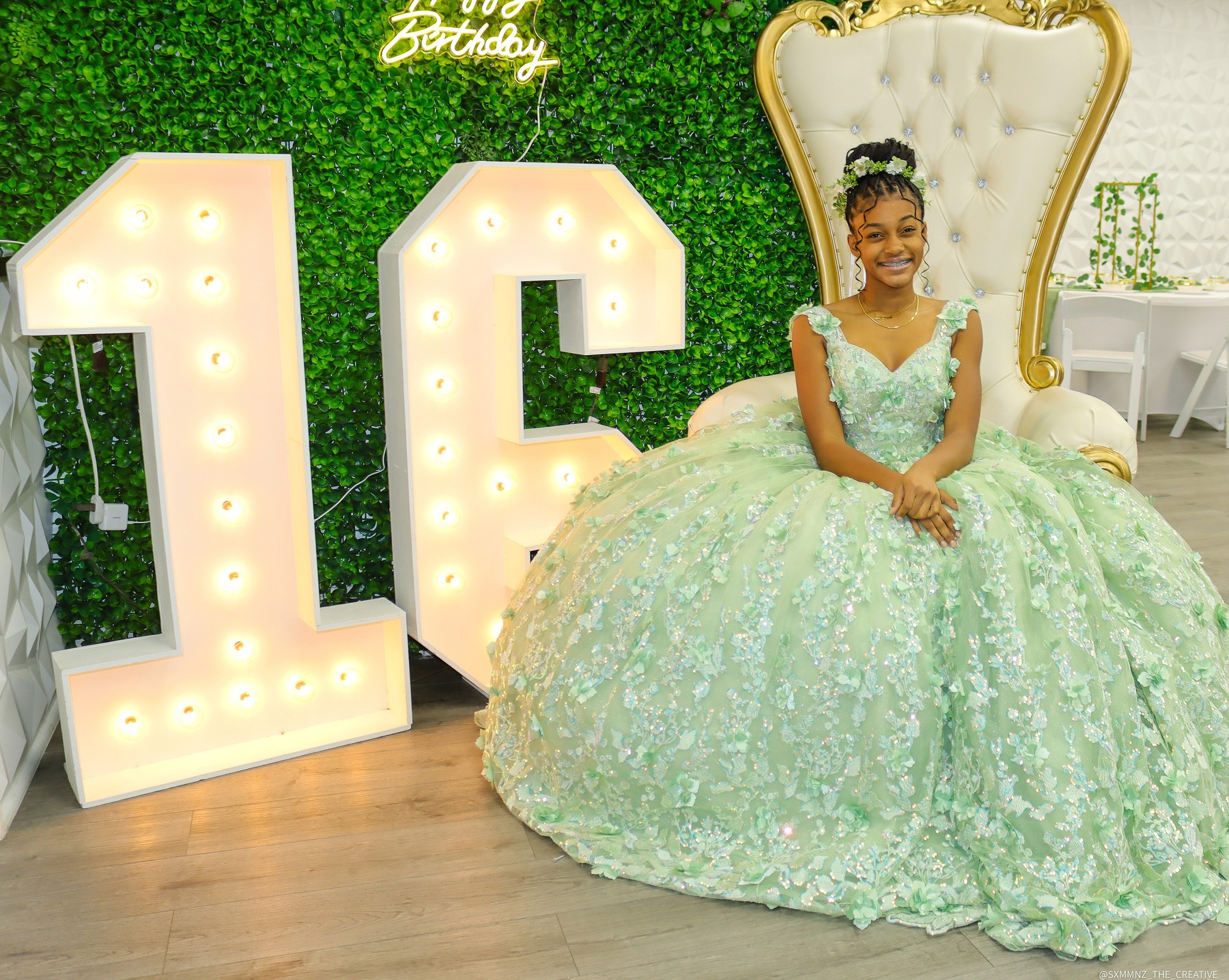 Sweet 16 celebrant in a mint gown beside illuminated 16 numerals